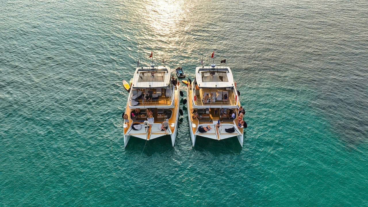 Twin catamaran yachts at golden hour